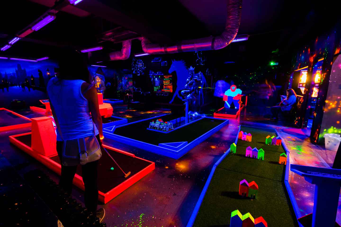 play a mini-golf game under uv lights