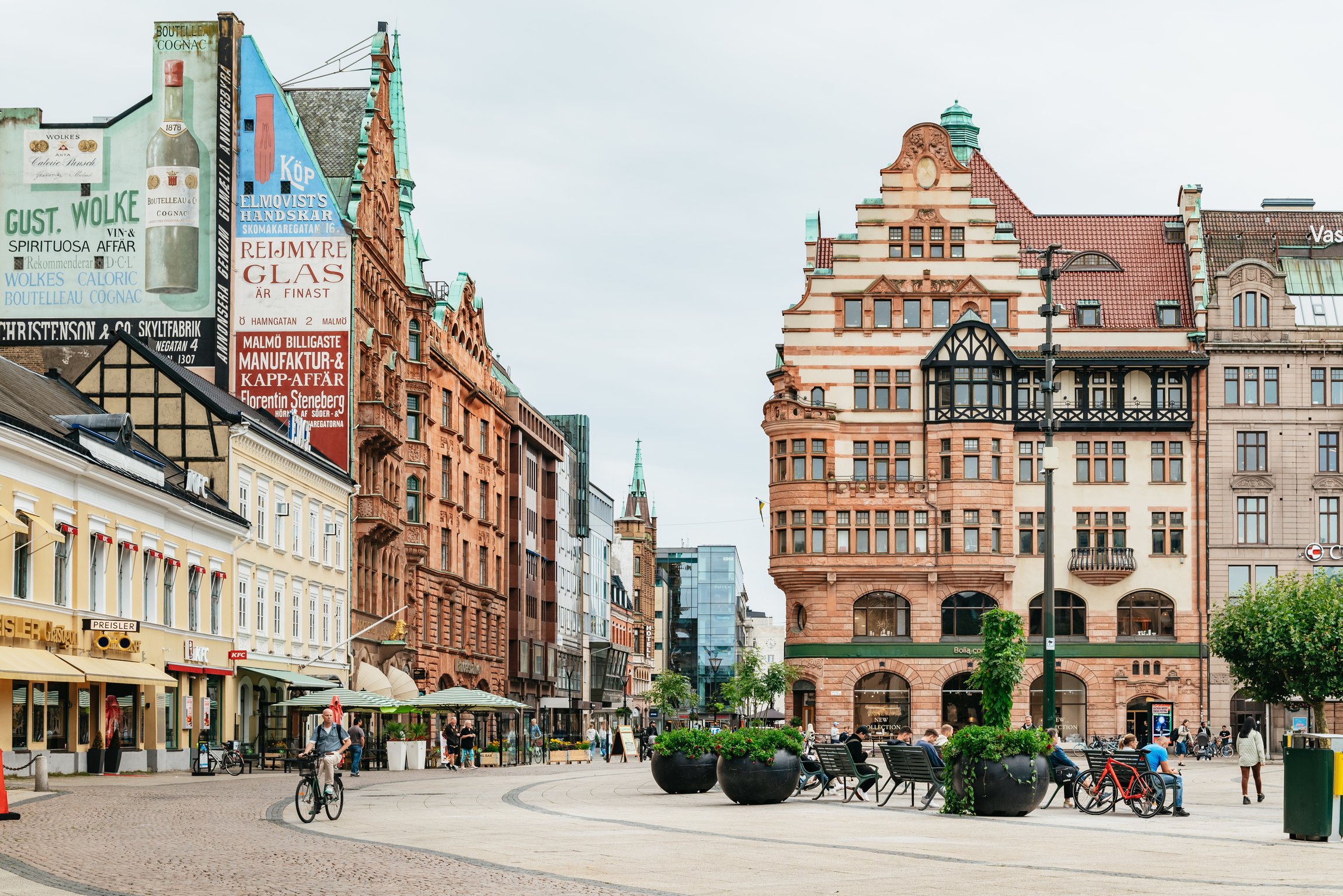 Ornate 19th-century facades and old painted shop signs on a pedestrian square