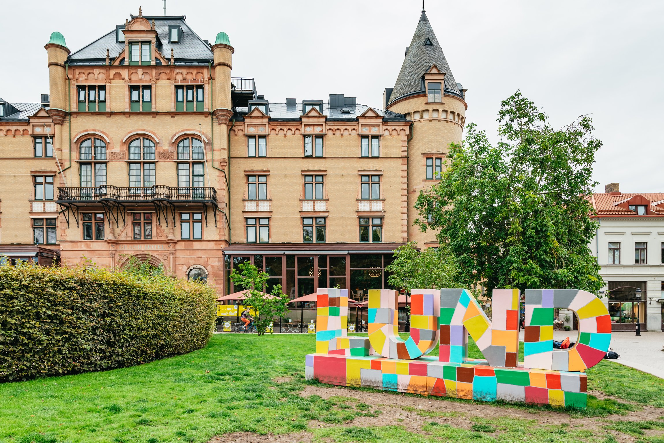 The colourful LUND letters on a lawn in front of a turreted hotel