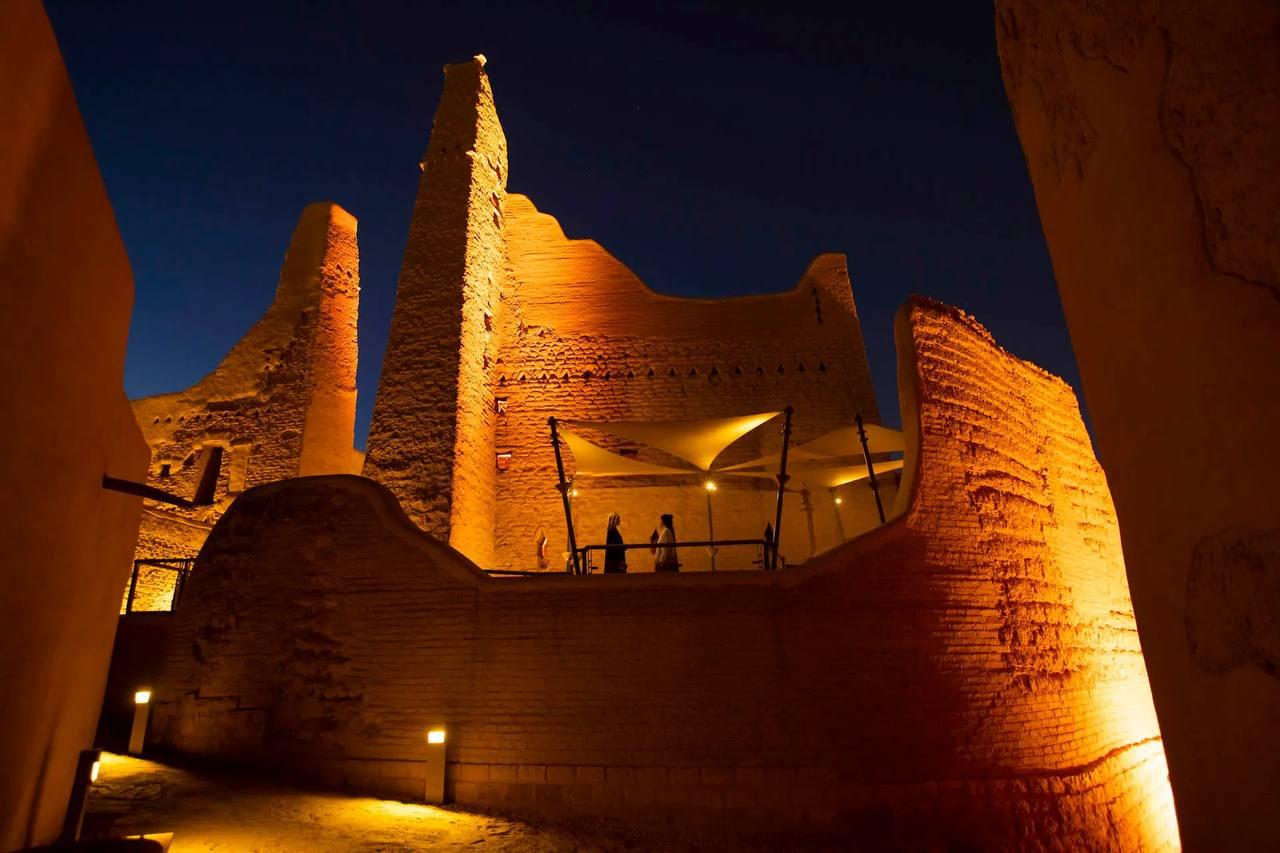 A floodlit mud-brick tower inside the At-Turaif World Heritage district in Diriyah at night