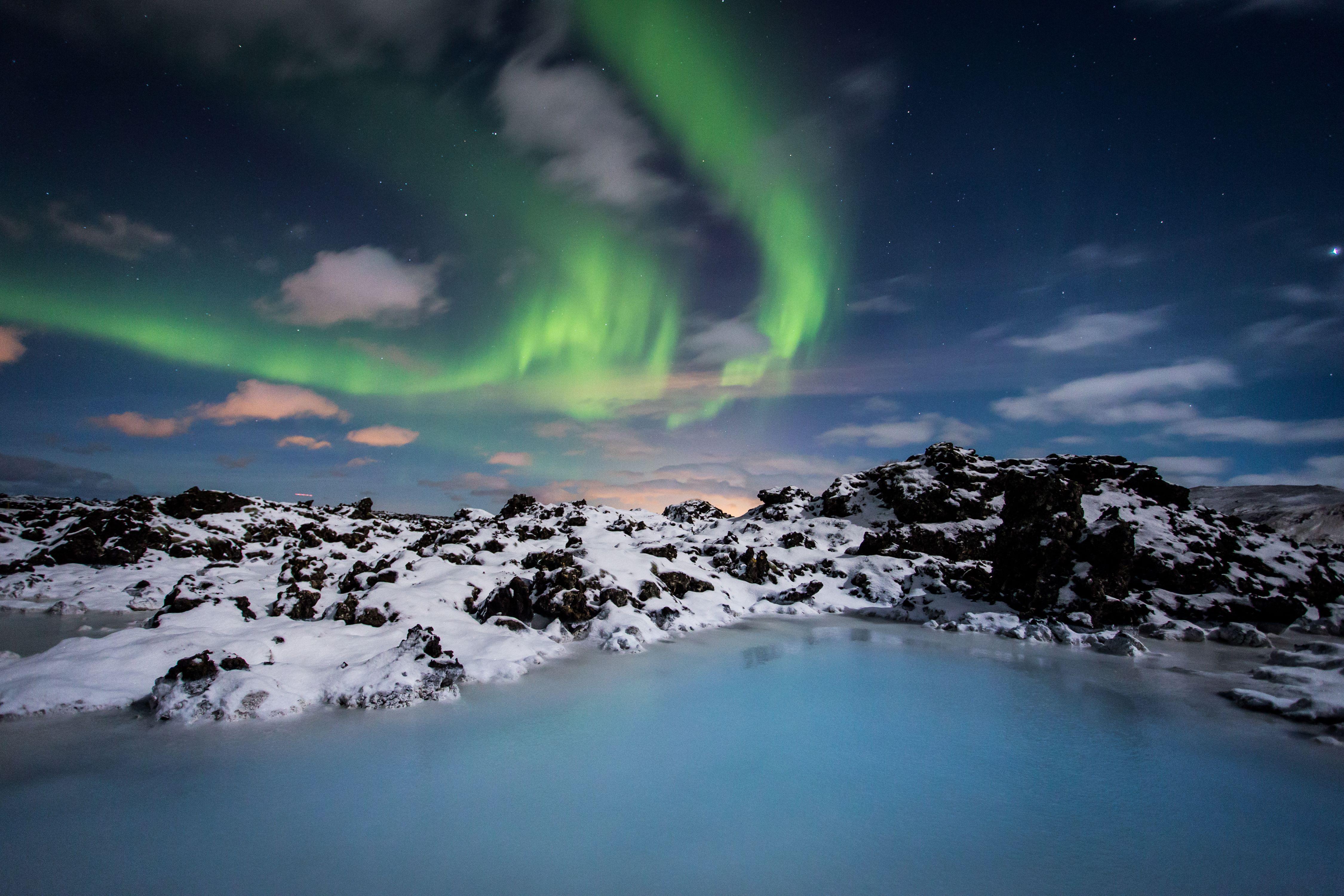 Steam rising off the Blue Lagoon's milky-blue water against the lava landscape, Grindavik Iceland