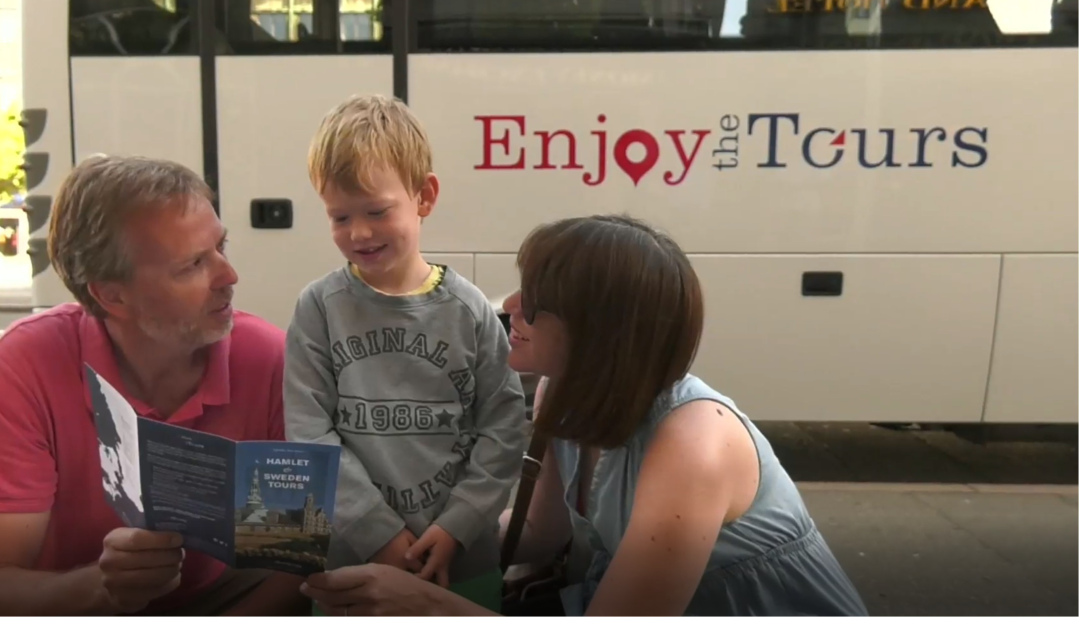 A family reading the tour leaflet in front of the coach