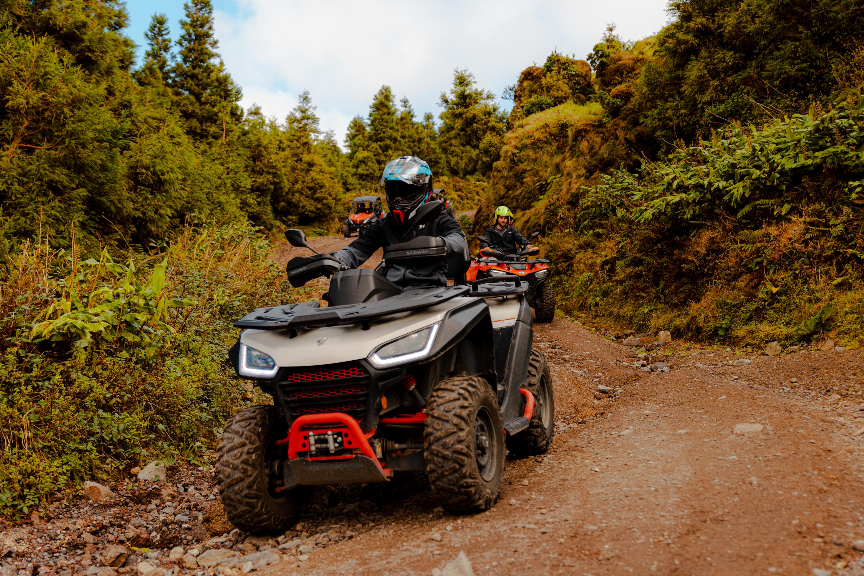 Quad rider climbing a rocky forest trail on São Miguel
