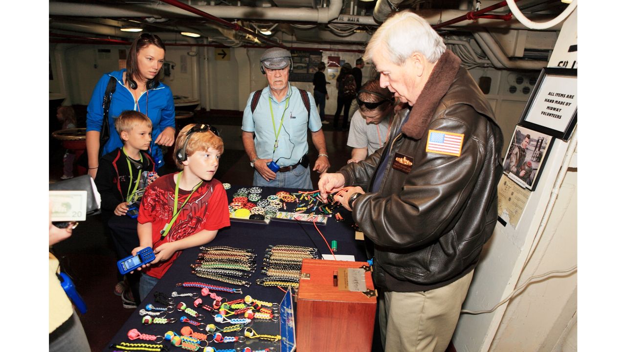Visitantes recorriendo la cubierta de vuelo y los aviones del USS Midway