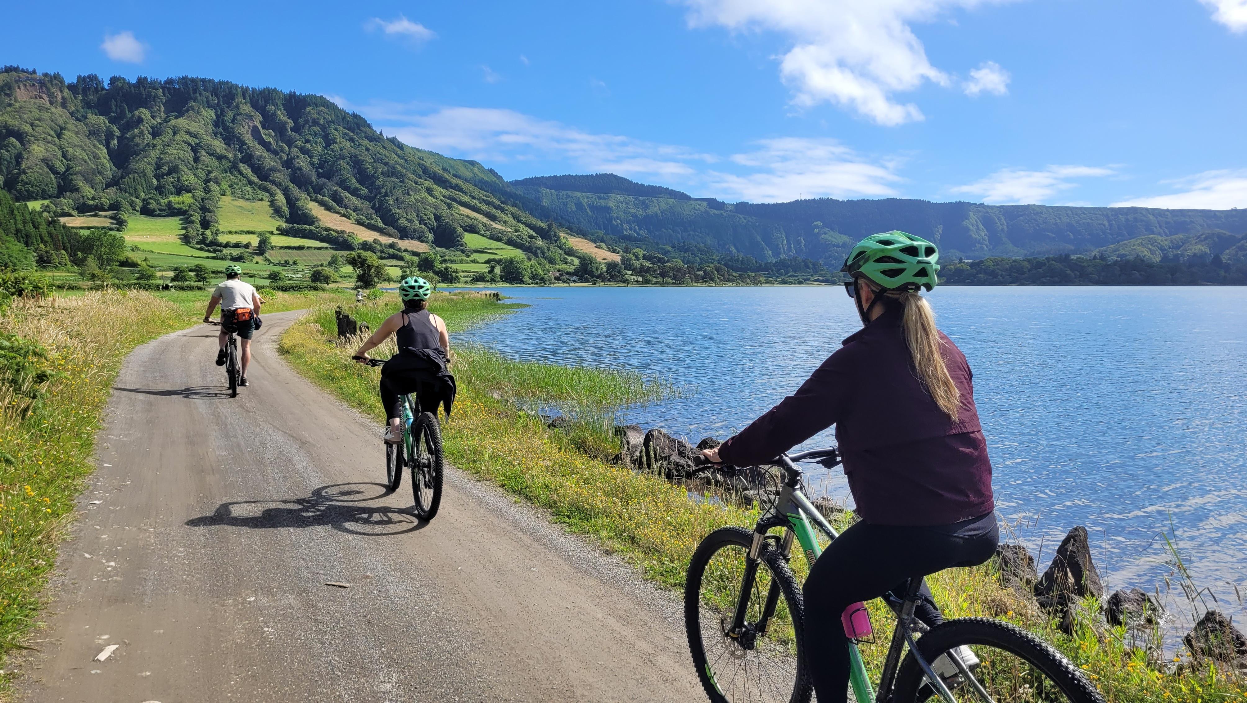 Two cyclists following the paved road beside Lagoa das Sete Cidades