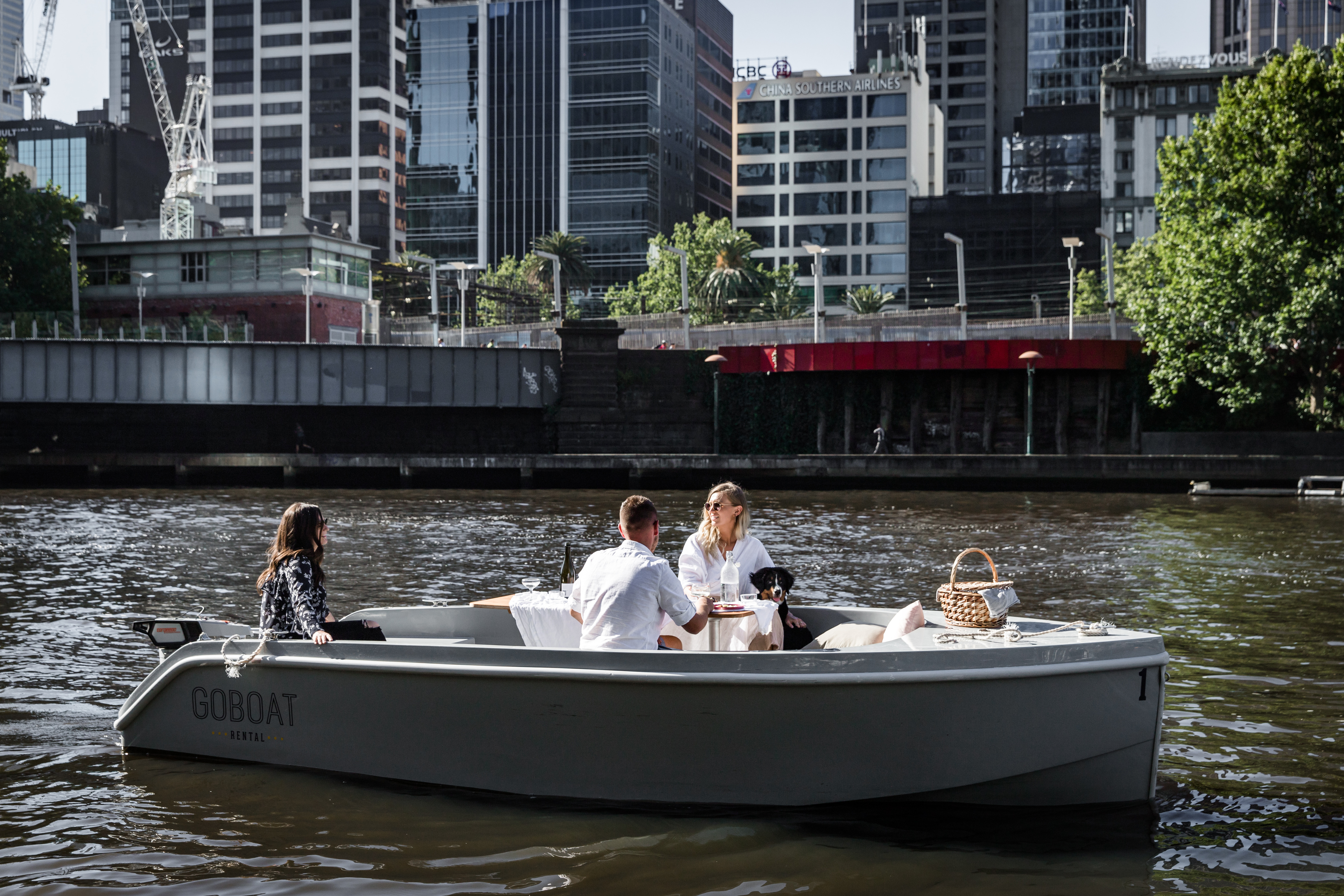 Friends on a GoBoat passing the city riverbank