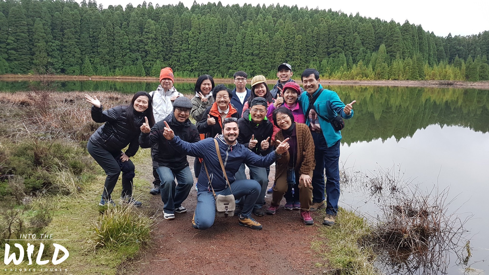 Small tour group beside a forest lake near Sete Cidades