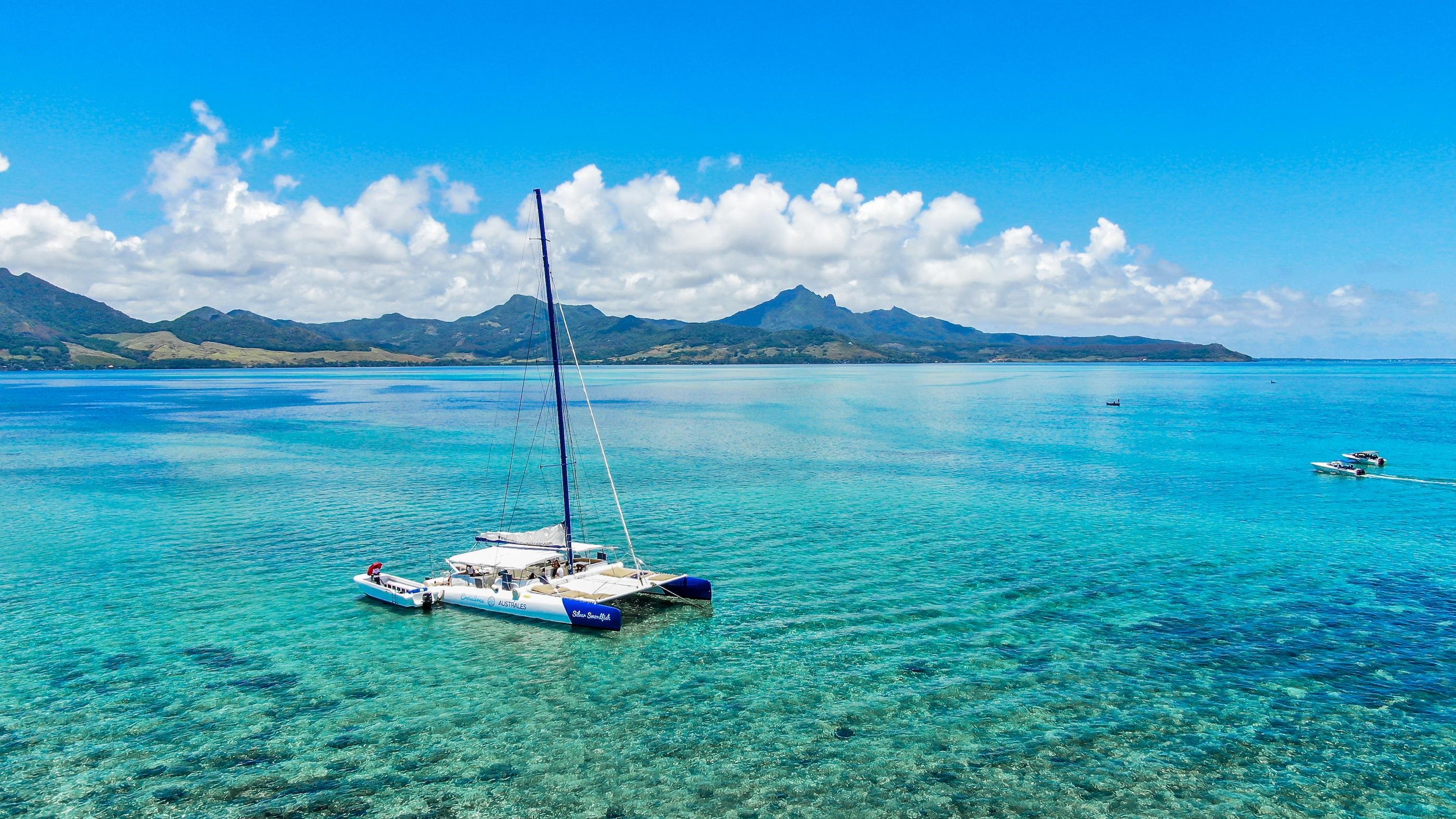 Sailing catamaran with the Mauritius coastline beyond