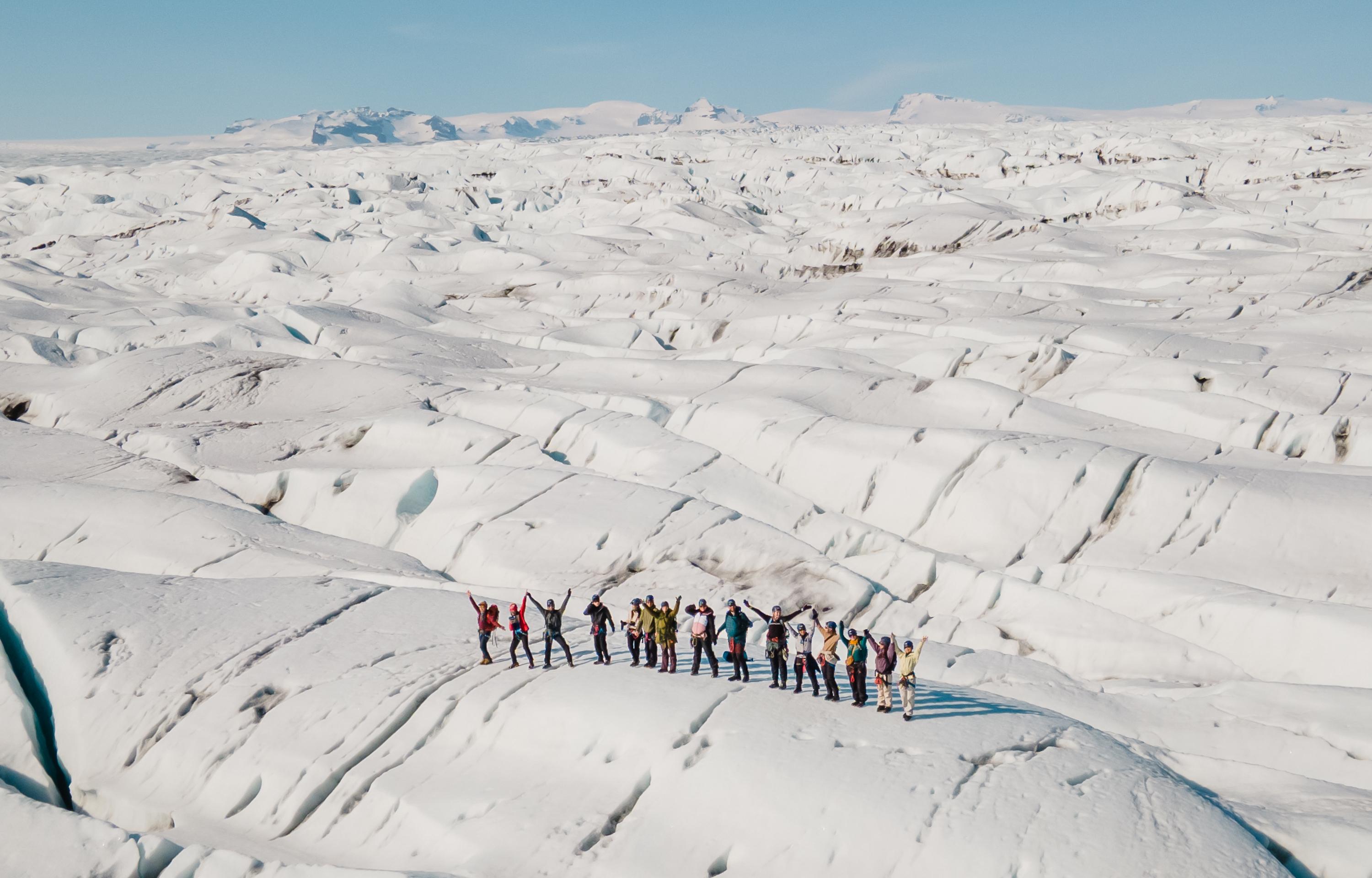 Harnessed glacier hikers celebrating on the crevassed ice of Breiðamerkurjökull