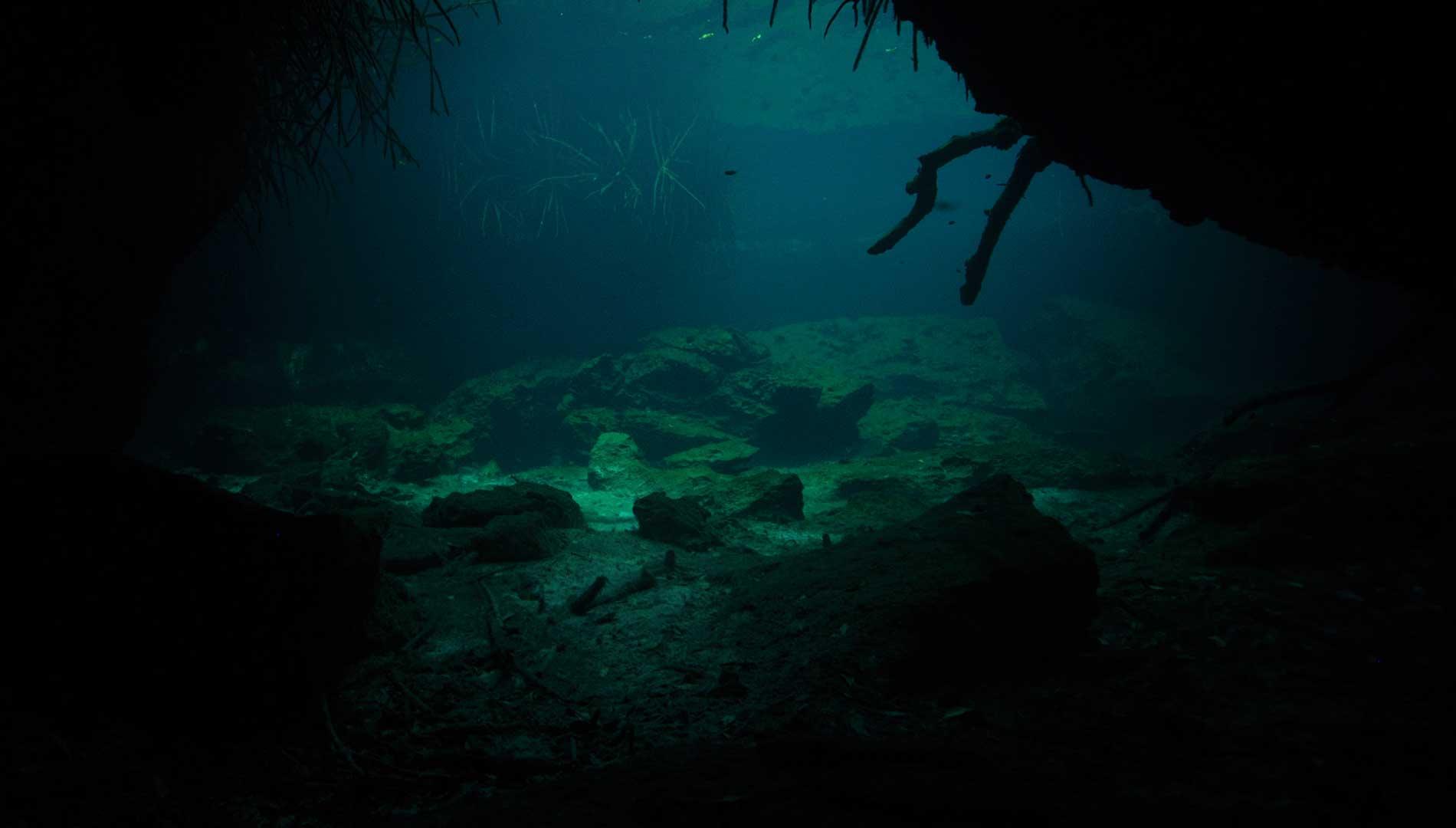 Blue cave water seen beneath an overhanging rock