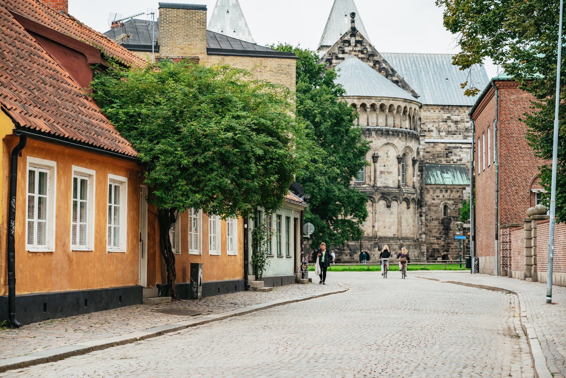 A cobbled street of low painted houses leading to Lund Cathedral