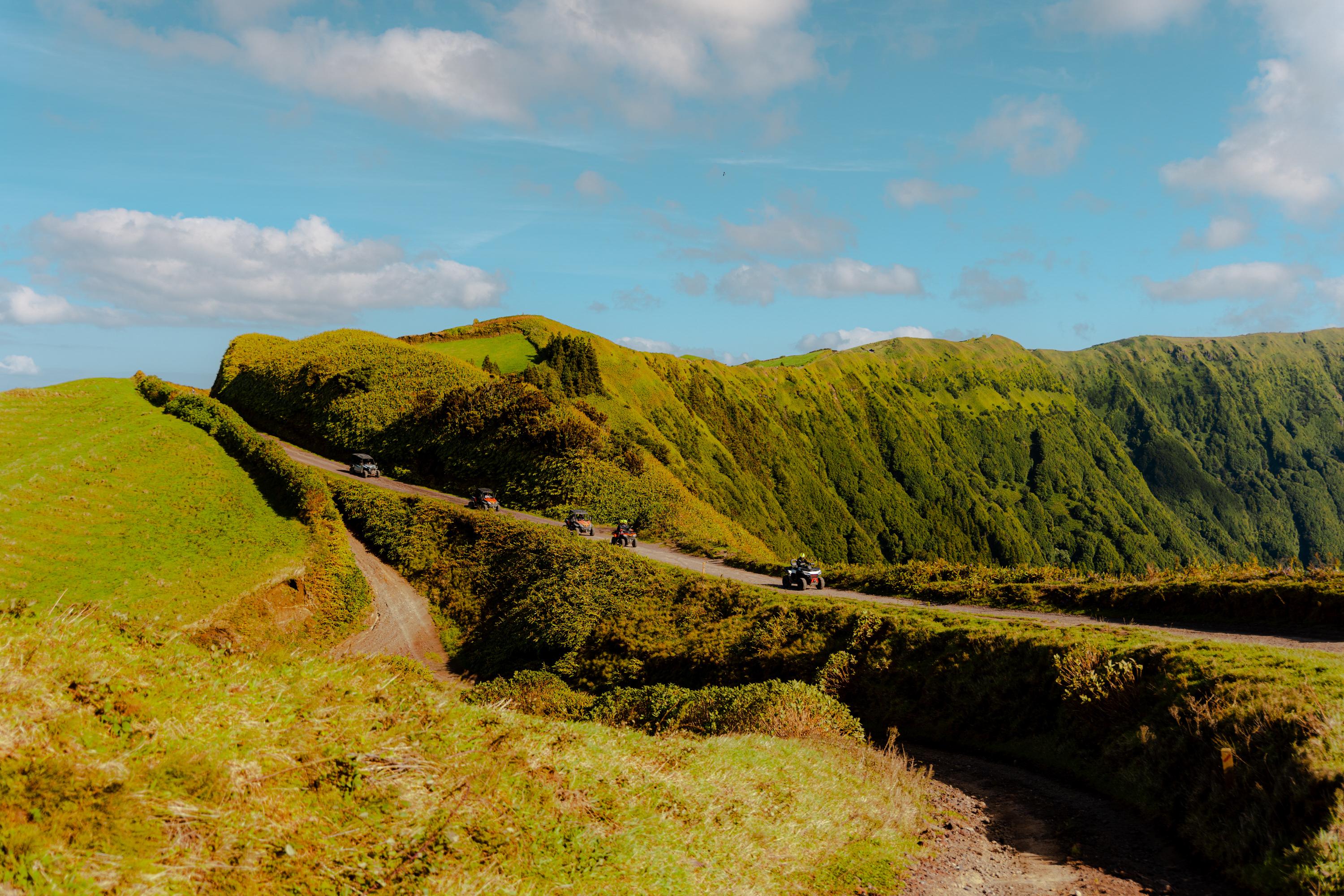 Guided line of ATVs crossing a green caldera track