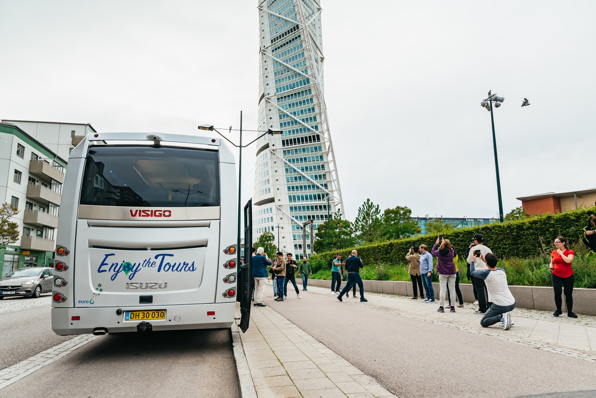 The tour minibus at the Turning Torso in Malmö, travellers photographing the tower