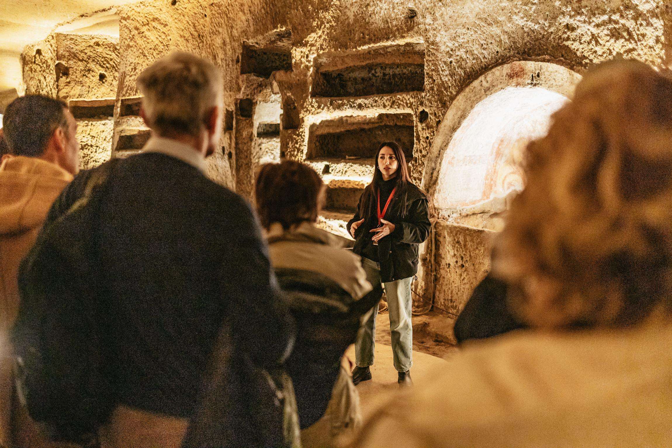 Guide leading visitors through the Catacombs of San Gennaro