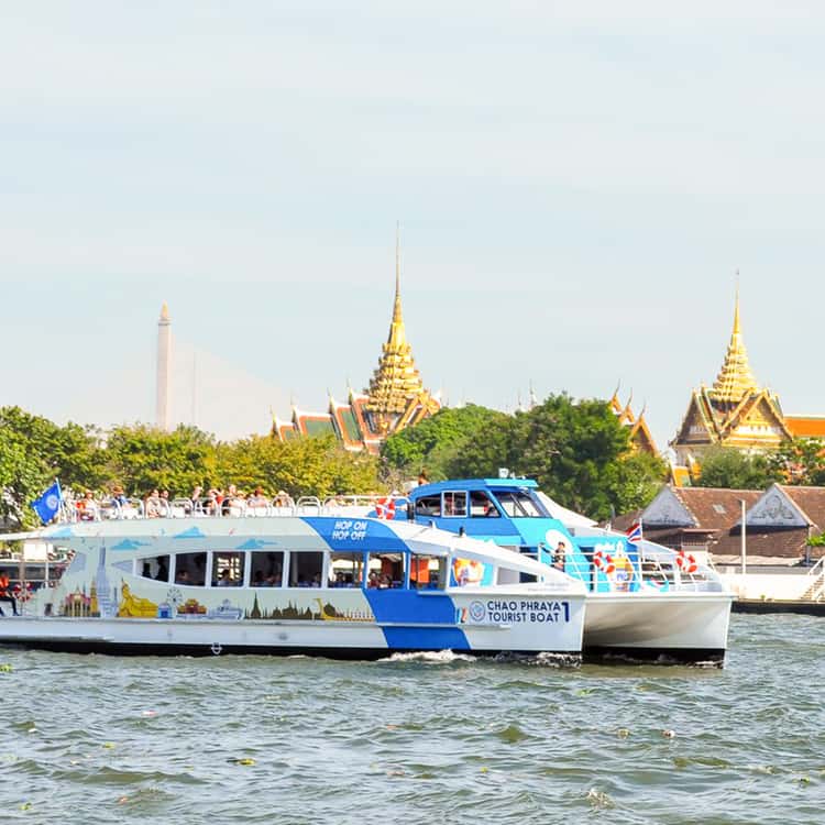 Blue-and-white Chao Phraya Tourist Boat cruising the Bangkok river