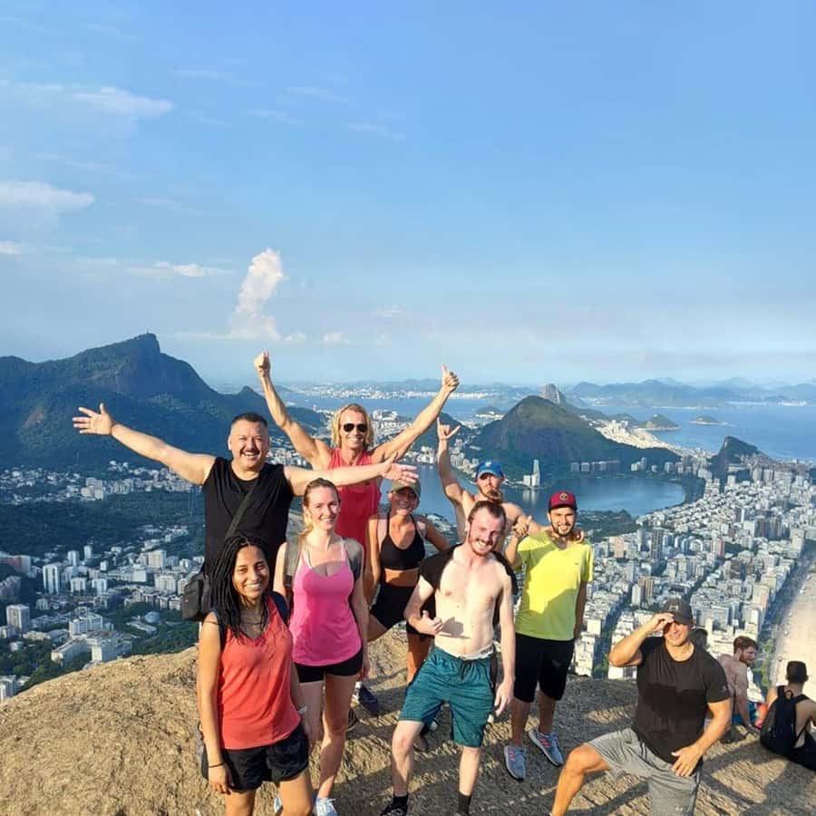 Grupo de senderistas celebrando en la cima de Morro Dois Irmãos con Río de Janeiro al fondo