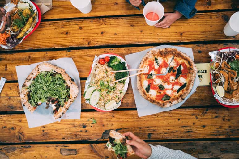 A table with various food items including pizza and salads.