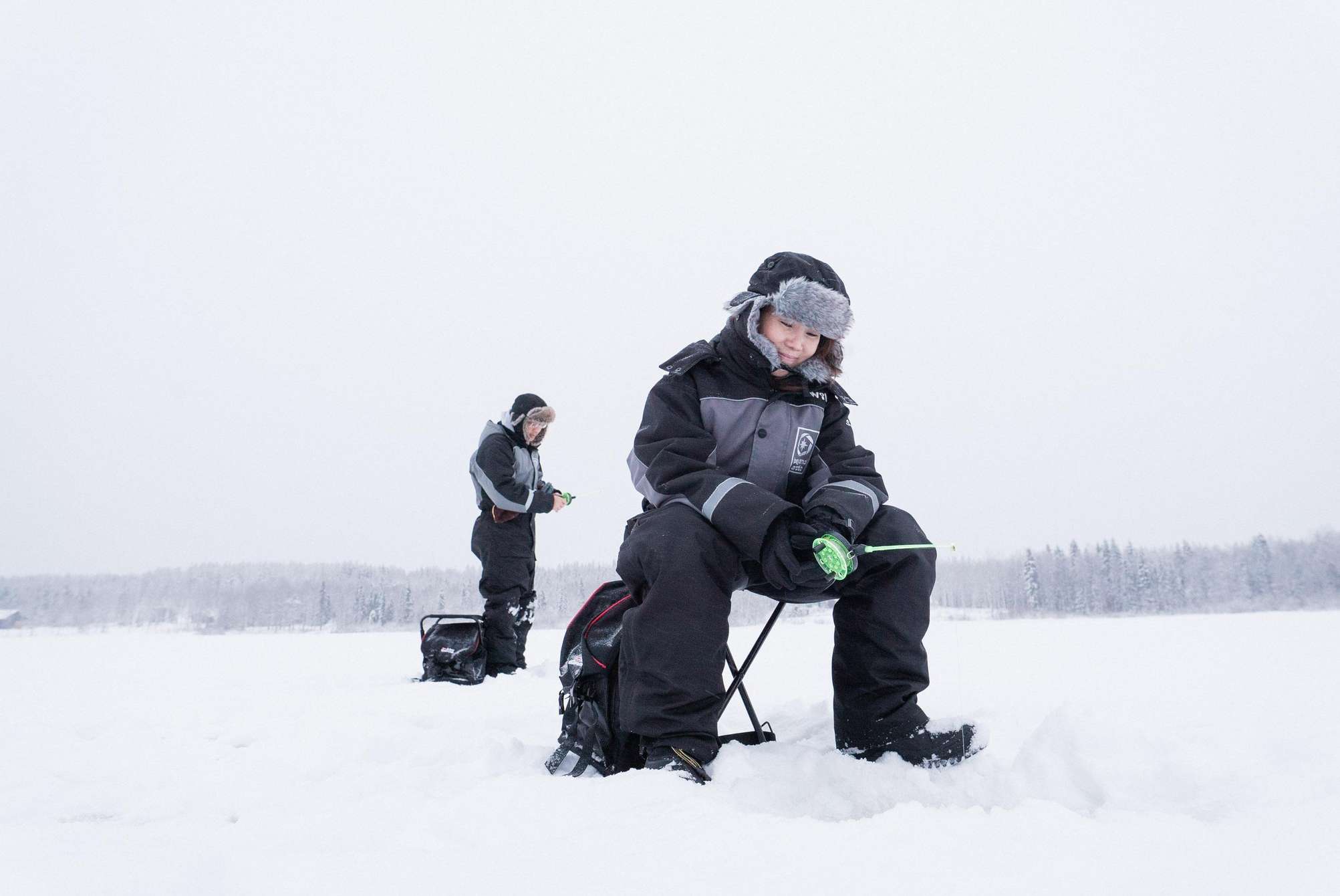 Eisangeln bei Rovaniemi mit Beyond Arctic: Loch in einen Meter dickes Eis gebohrt, auf einem zugefrorenen See in Lappland, Lagerfeuer in einer traditionellen Kota und verschneite Winterlandschaft