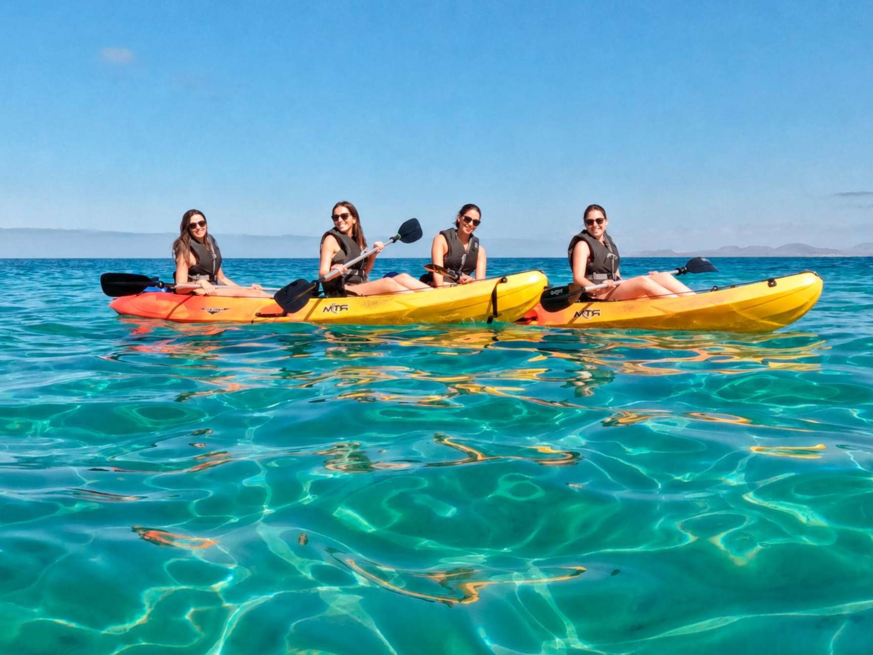 Kayaks biplaces sur l'eau transparente au large de Playa Blanca, en route vers Papagayo