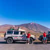 Two jeeps in front of Teide, guests on roof