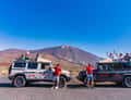 Two jeeps in front of Teide, guests on roof