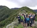 Hikers waving on green ridge