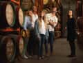 Group tasting among wine barrels
