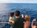 Family watching whale from boat