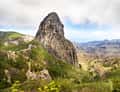 Roque de Agando rock above green La Gomera hills