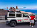 White safari jeep with guests, red-shirt guide