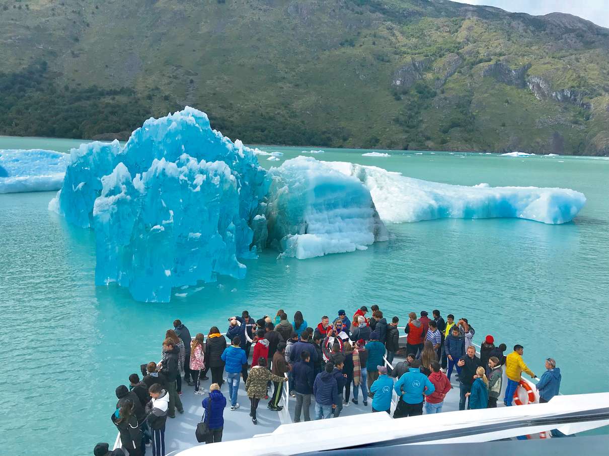 Catamaran sailing past a towering glacier front in Los Glaciares National Park near El Calafate