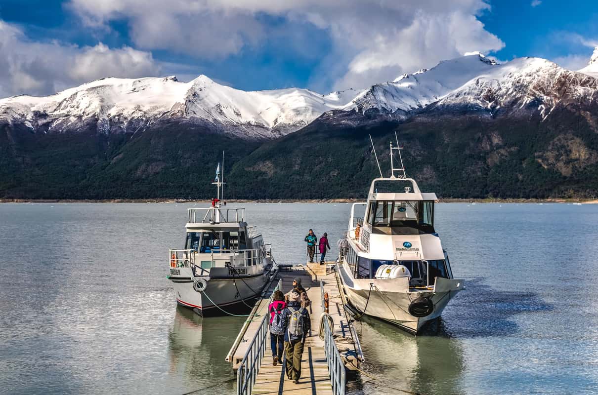 Travelers in crampons walking on the blue ice of Perito Moreno Glacier in Patagonia