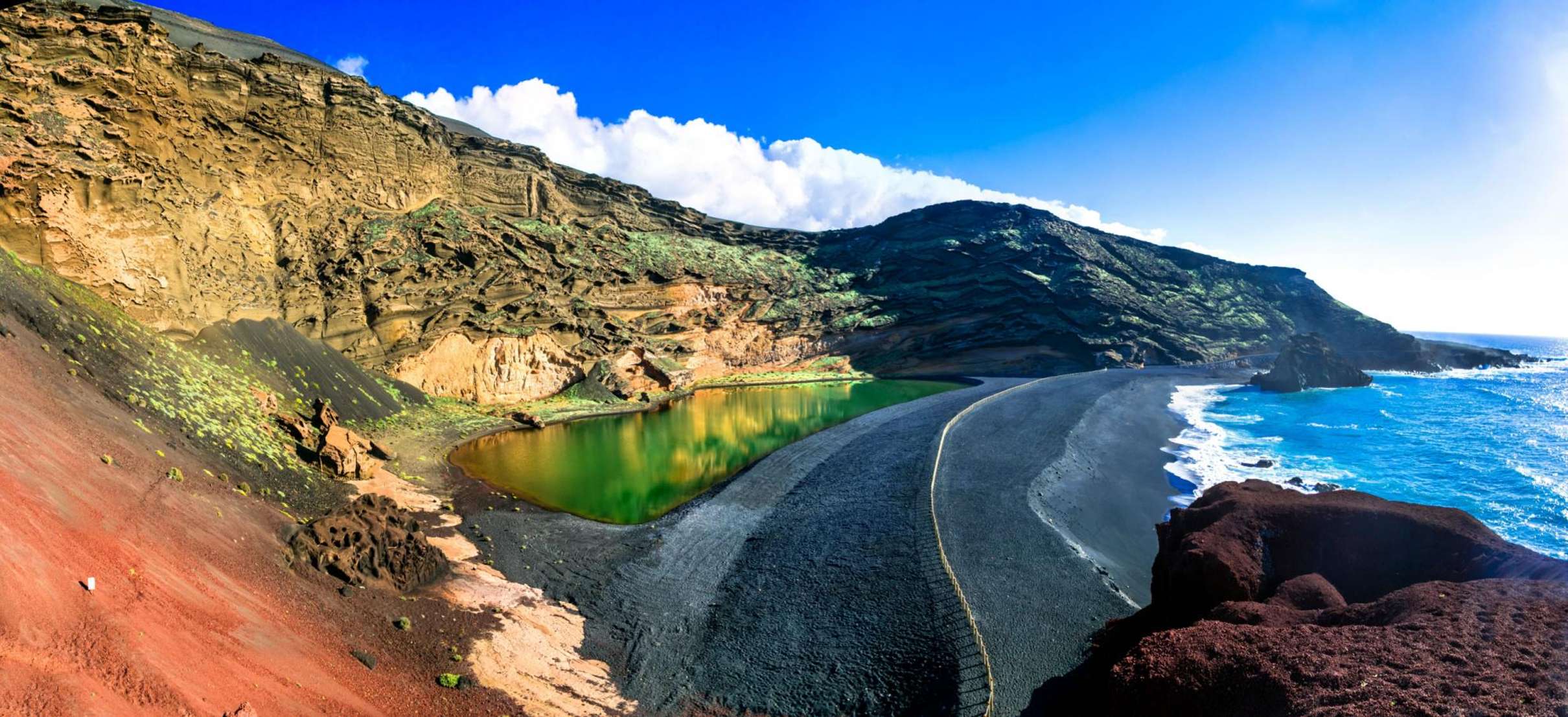 Lago Verde d'El Golfo entre la falaise volcanique et la plage de sable noir, à Lanzarote