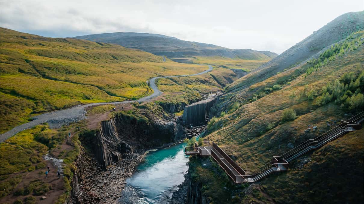 Green slopes of the Jökuldalur valley rising above the river canyon on a summer day
