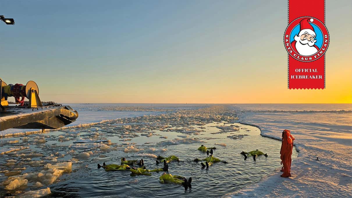Guests floating in survival suits in a channel of broken ice under a golden evening sky