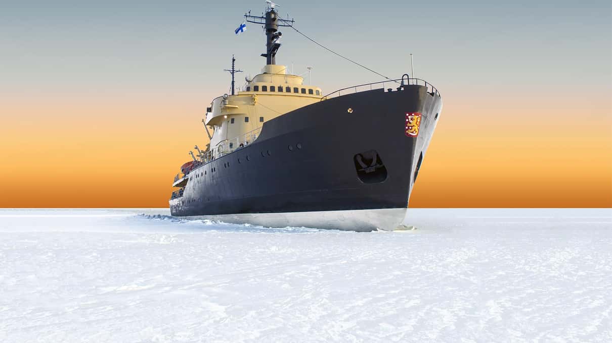 The icebreaker Sampo with its black hull and cream superstructure in the sea ice under an orange evening sky