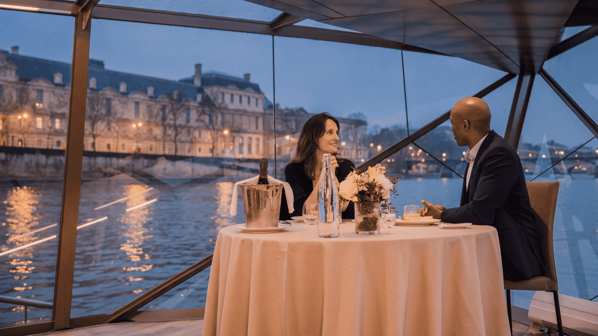Mesas junto a los ventanales en la cena crucero de Bateaux Mouches por el Sena