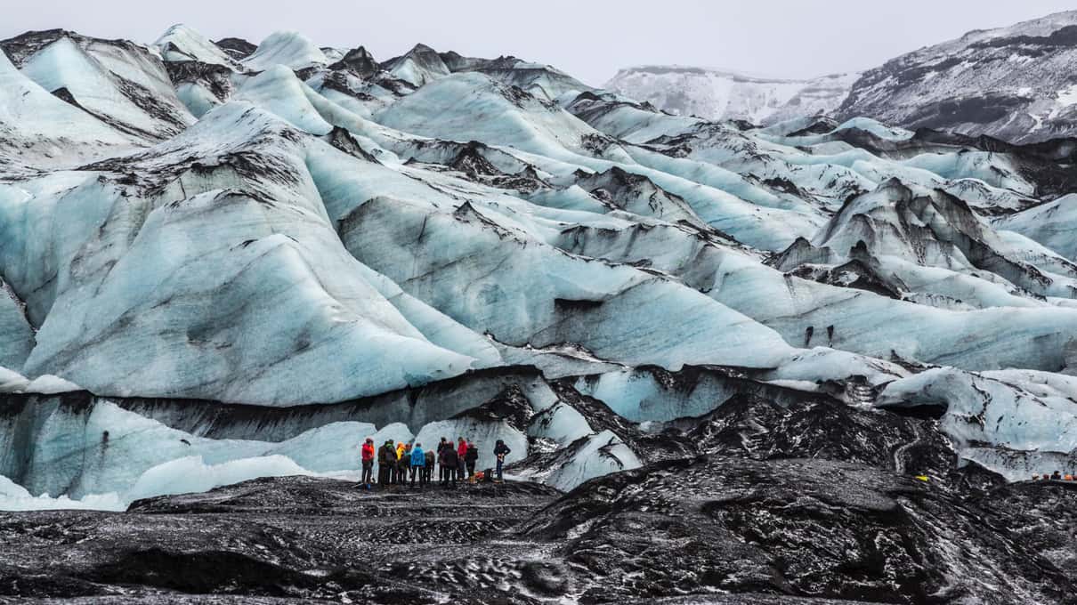 The ash-streaked ridges of the Sólheimajökull glacier tongue seen from the slopes above