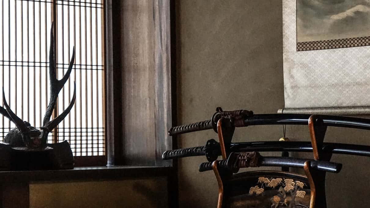 Ein Katana auf einem schwarz lackierten Ständer auf dem Tatami-Boden von Warakus Samurai-Haus