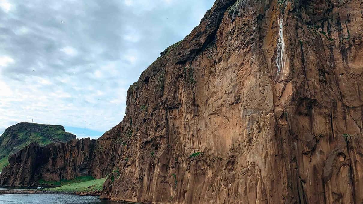 Towering dark basalt sea cliffs rising straight out of the Atlantic in the Westman Islands