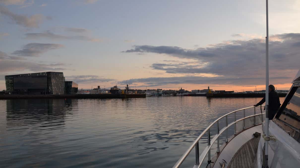 The bow of a Harpa Yachts motor yacht leaving Reykjavik harbour at dusk