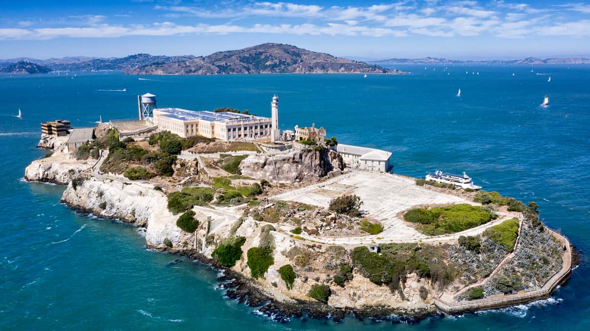 Červený otevřený patrový vyhlídkový autobus přejíždí most Golden Gate v San Franciscu