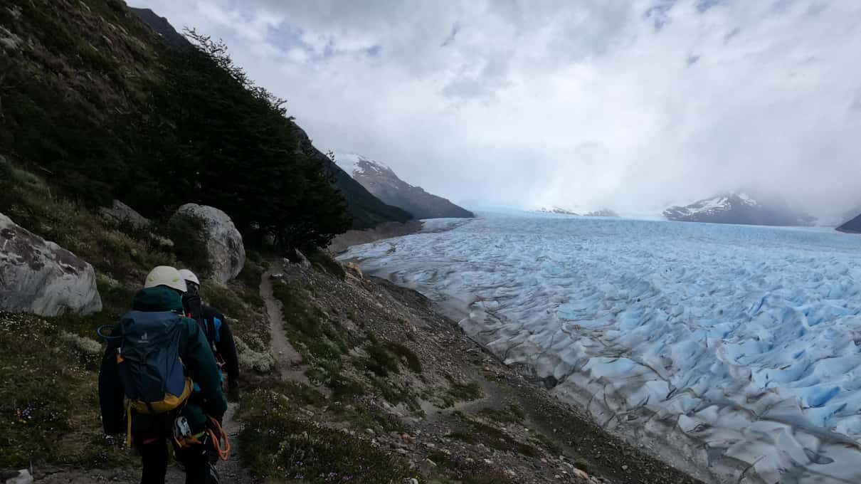 A hiker on the moraine trail high above the cracked surface of Perito Moreno Glacier