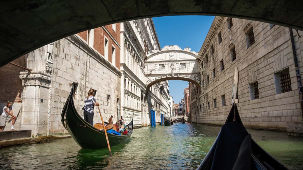 Gondole nel rio sotto il Ponte dei Sospiri, visto da sotto l’arco di un altro ponte
