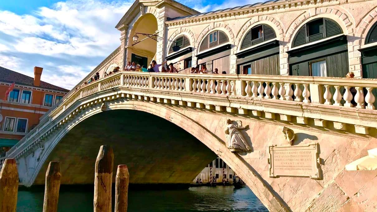 Die Rialtobrücke mit ihren weißen Arkaden über dem Canal Grande an einem sonnigen Tag