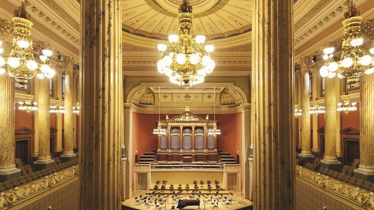 The gold and white Dvořák Hall of the Rudolfinum in Prague with its organ and chandeliers, empty before a concert
