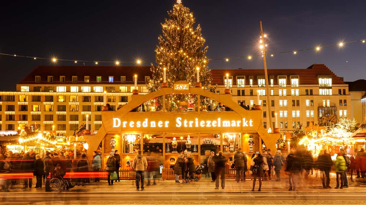 The Dresden Striezelmarkt at night, with its tall wooden Christmas pyramid rising above rows of lit stalls