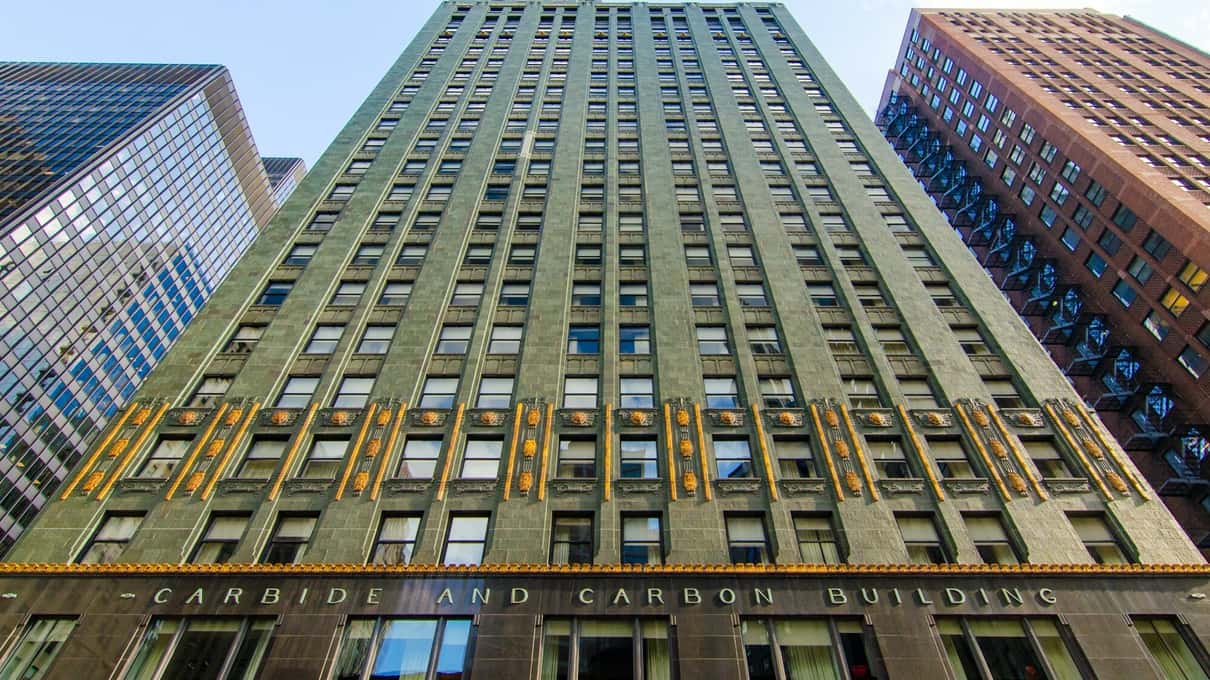 Il Carbide and Carbon Building, verde scuro e oro, su Michigan Avenue tra edifici vicini più chiari, visto dalla strada