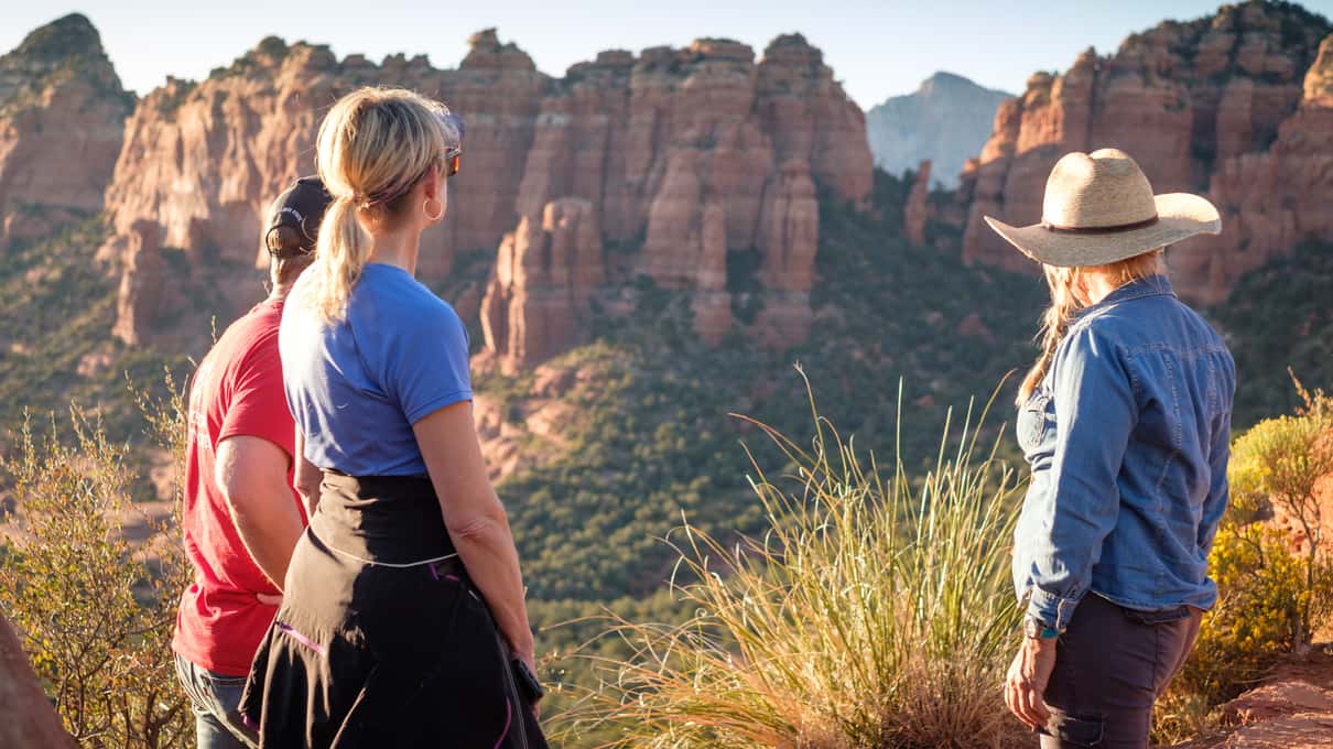 An open-top jeep tilted on a steep rocky off-road trail among Sedona's red rock formations