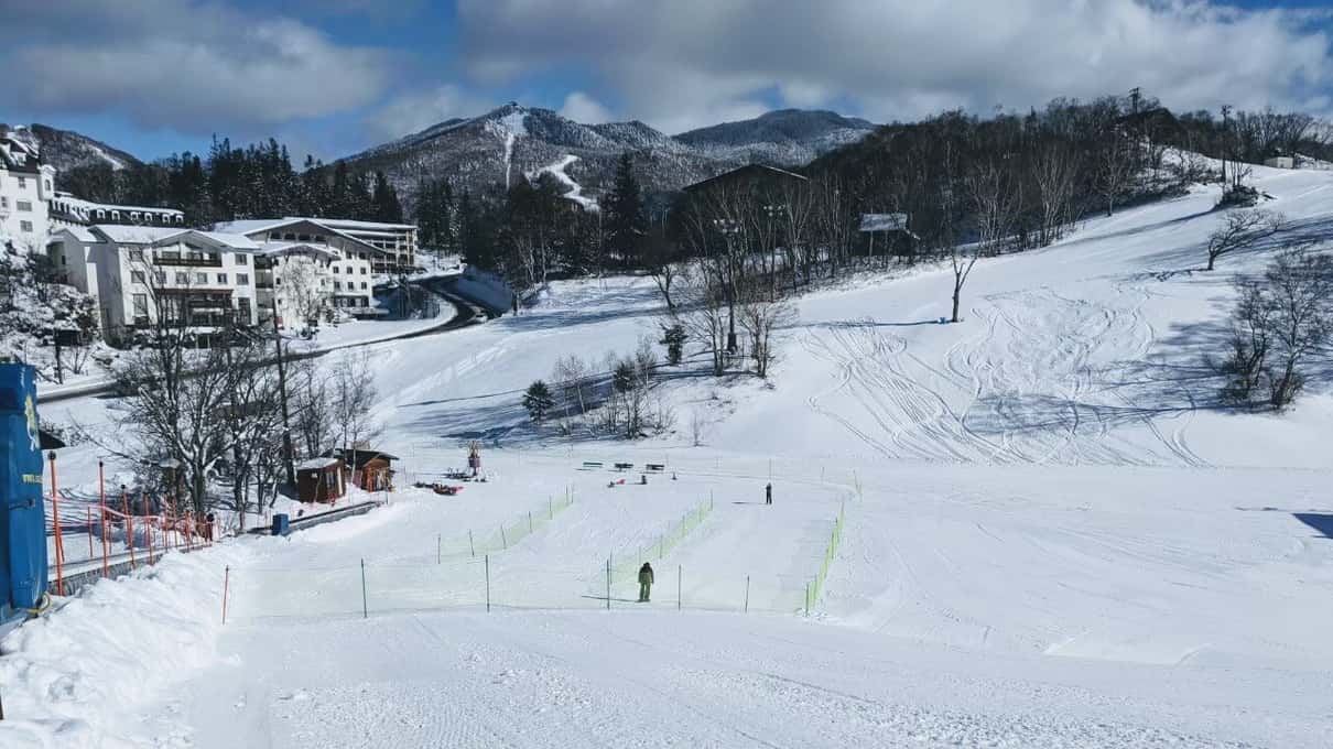 Ski slopes and hotels at Shiga Kogen under a blue winter sky, the resort above the monkey park